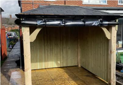 A timber gazebo fitted with black side panels